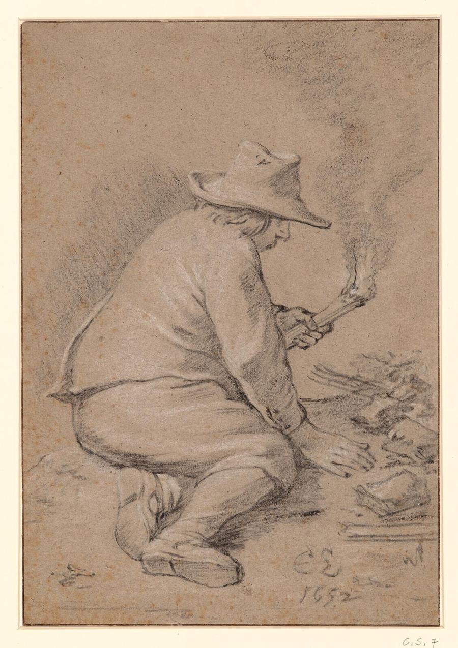 Een man zit op de grond met een fakkel in de hand